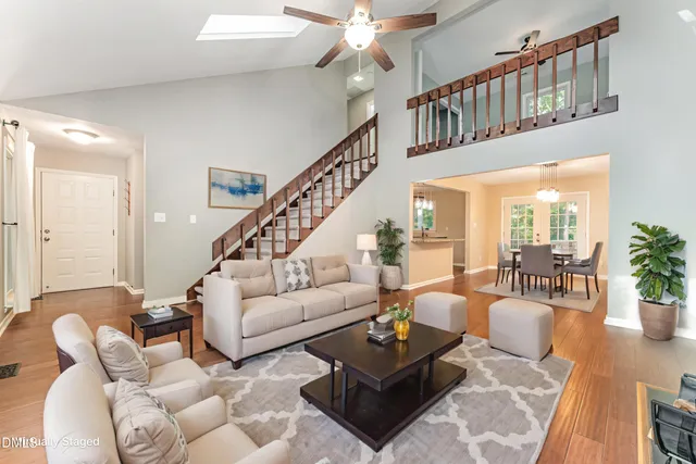 a living room with furniture a chandelier and a rug