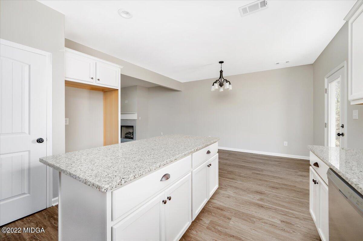229 Davis Road Gray, GA 31032 - Photo 11 of 30 a kitchen with a wooden floor and chandelier