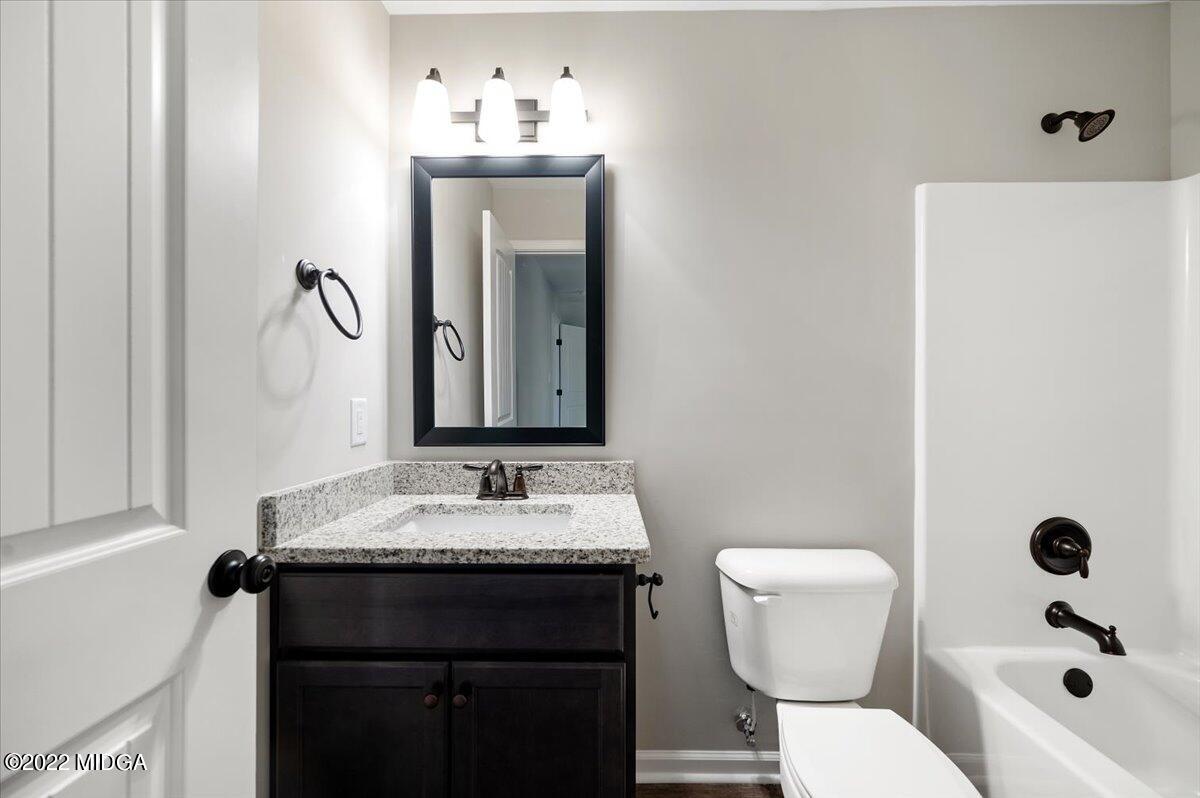 229 Davis Road Gray, GA 31032 - Photo 23 of 30 a bathroom with a granite countertop sink and a mirror