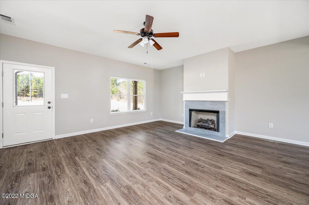 229 Davis Road Gray, GA 31032 - Photo 5 of 30 an empty room with windows a fireplace