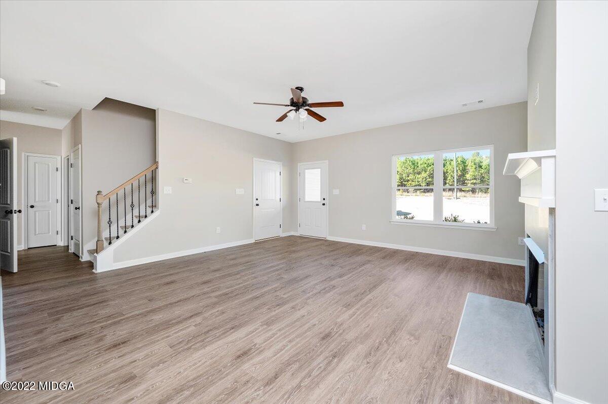229 Davis Road Gray, GA 31032 - Photo 6 of 30 an empty room with wooden floor and chandelier fan