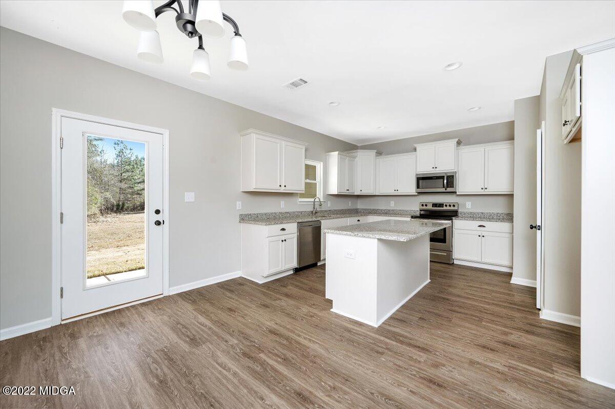 229 Davis Road Gray, GA 31032 - Photo 8 of 30 a kitchen with stainless steel appliances a white cabinets and wooden floors