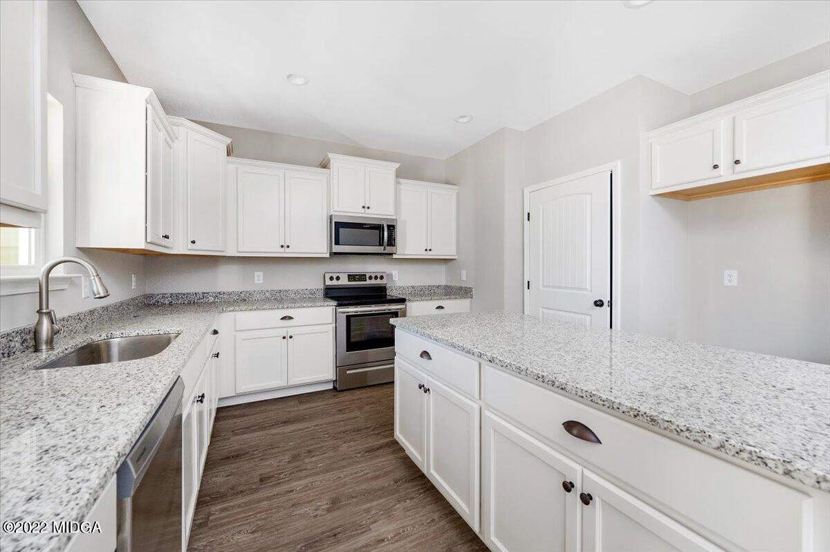 229 Davis Road Gray, GA 31032 - Photo 9 of 30 a kitchen with granite countertop white cabinets and white appliances
