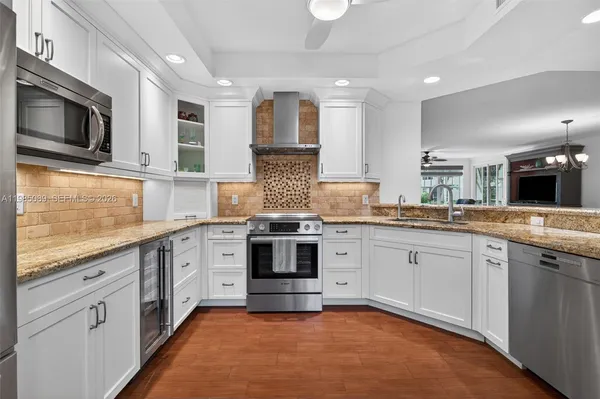 a large kitchen with stainless steel appliances granite countertop a stove and a sink