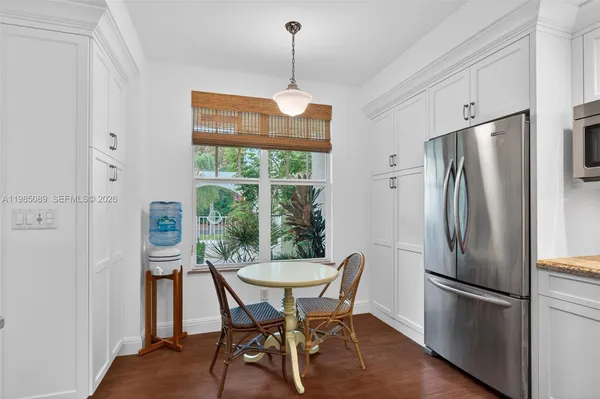 a kitchen with stainless steel appliances a refrigerator a microwave a dining table and chairs