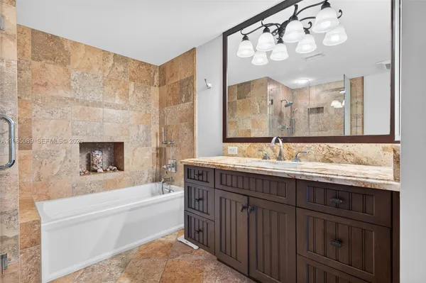 a bathroom with a bathtub a sink and a large mirror