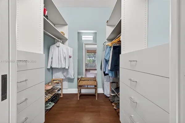 a view of walk in closet with clothes and shoes