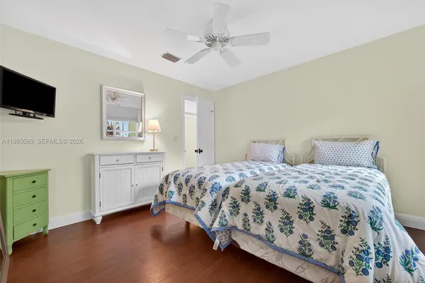 a bedroom with a bed and a flat tv screen on dresser