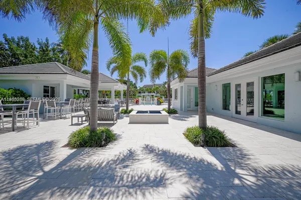 a view of a patio with a table and chairs under palm tree