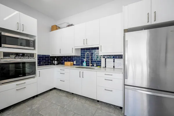 a kitchen with white cabinets and stainless steel appliances