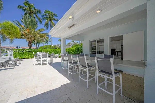 a view of a patio with table and chairs potted plants and palm trees