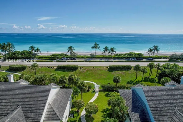 a front view of a house with yard and trees