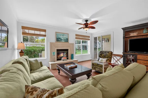 a living room with furniture a flat screen tv and a fireplace