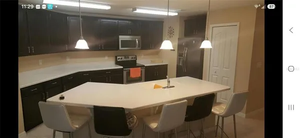 a kitchen with a table chairs and a refrigerator