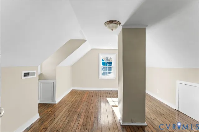 a view of empty room with wooden floor