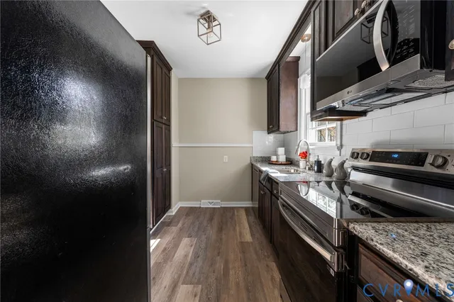 a kitchen with a sink and wooden floor