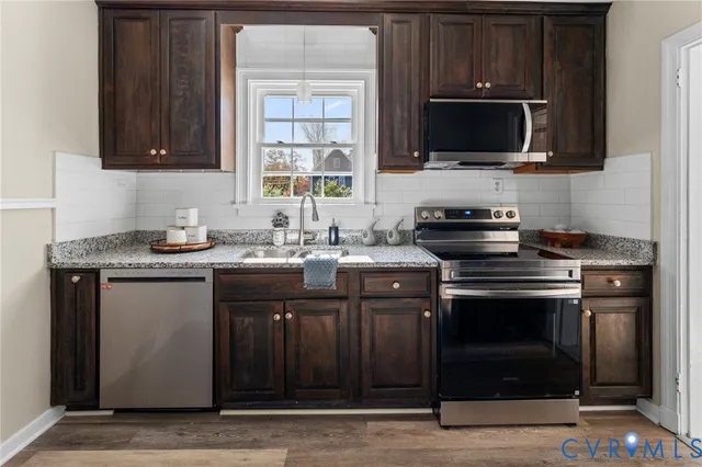 a kitchen with stainless steel appliances a stove a sink and a microwave