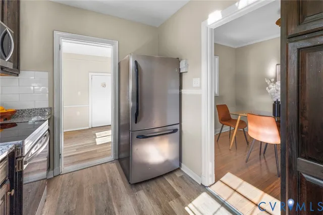 a kitchen with a refrigerator and wooden floor