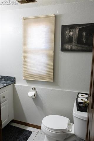 8115 Mustang Road Colorado Springs, CO 80908 - Photo 45 of 48 Bathroom with tile patterned flooring, a textured wall, and vanity
