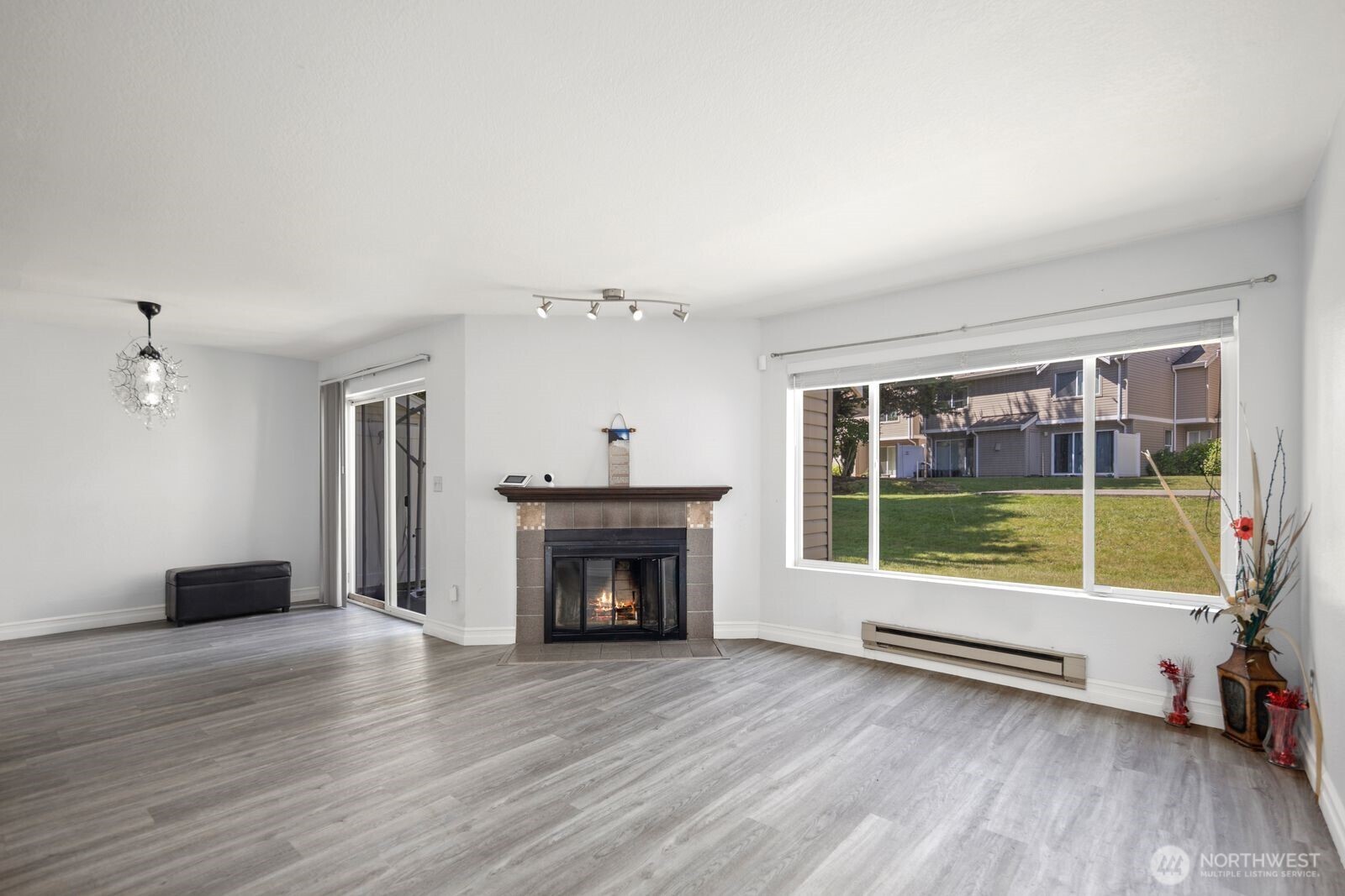2100 South 336th Street, Unit G3 Federal Way, WA 98003 - Photo 3 of 27 a view of an empty room with wooden floor fireplace and a window