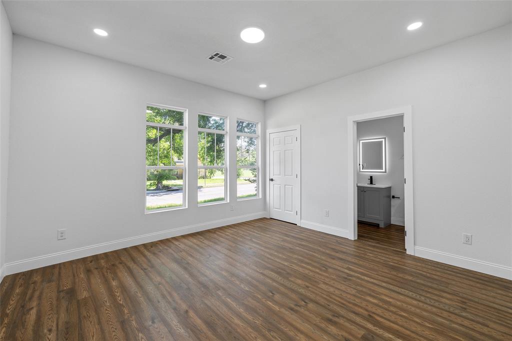 2023 Bosque Boulevard Waco, TX 76707 - Photo 5 of 26 Spacious room featuring three large windows, recessed lighting, and wood-finish flooring
