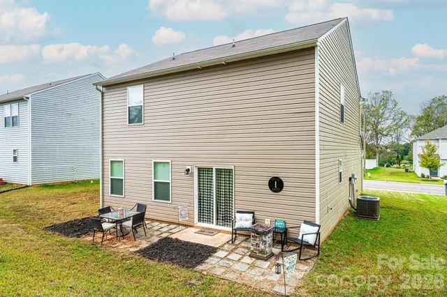 a view of a small house with yard and sitting area