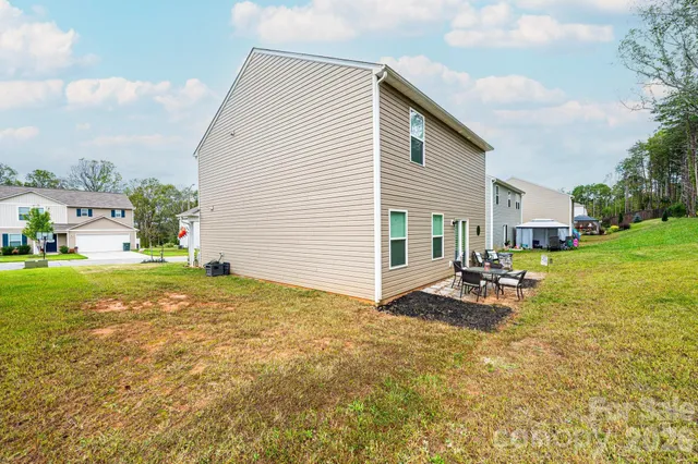 a view of a house with backyard and sitting area