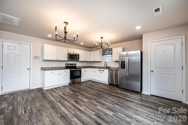 a kitchen with refrigerator cabinets and wooden floor