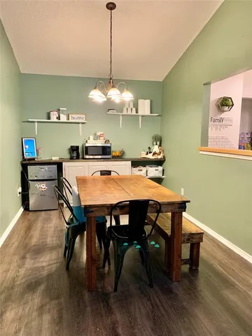 a view of a dining room and livingroom with furniture wooden floor a chandelier