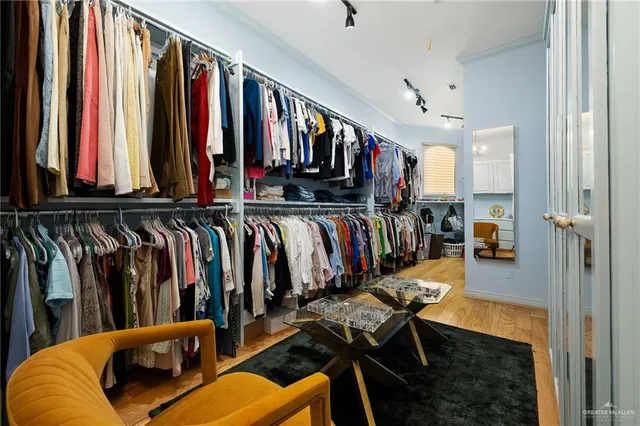 a view of walk in closet with clothes and shoes