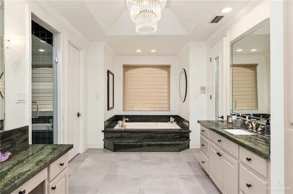 a spacious bathroom with a double vanity sink a mirror and a bathtub