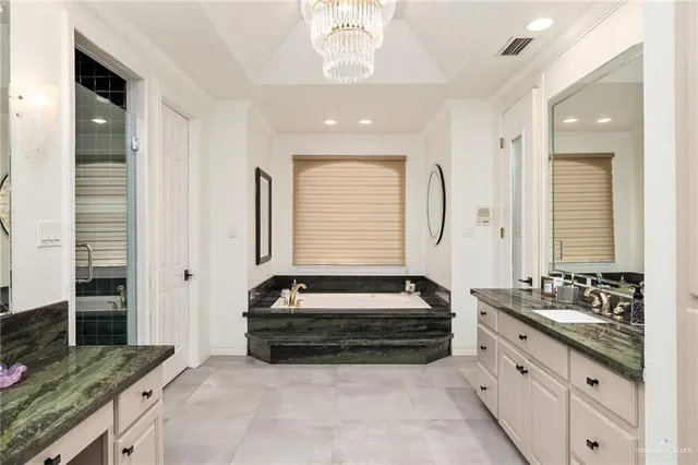 a bathroom with a granite countertop tub and a sink