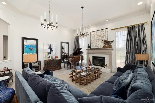 a living room with furniture a fireplace and a chandelier