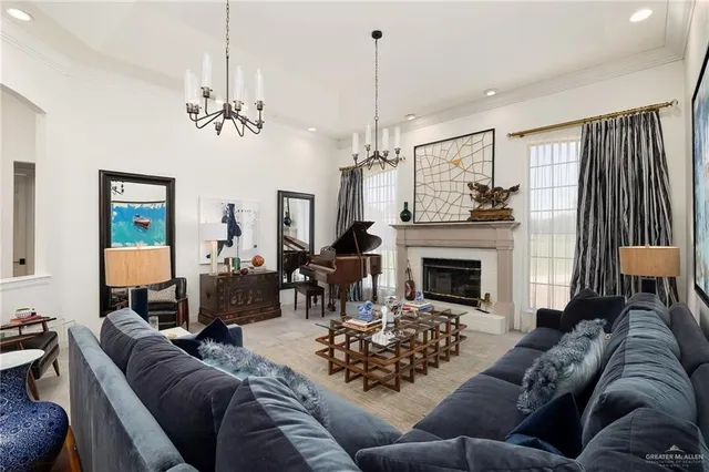 a living room with furniture a fireplace and a chandelier