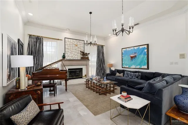 a living room with furniture a fireplace and a chandelier