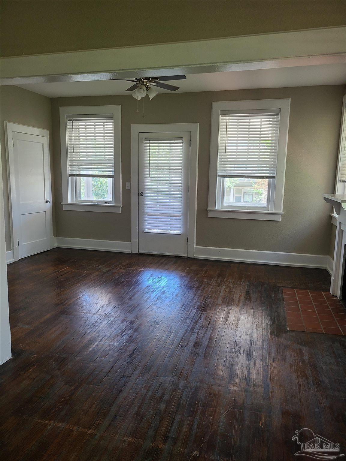 504 North Spring Street, Unit B Pensacola, FL 32501 - Photo 12 of 14 an empty room with wooden floor and windows