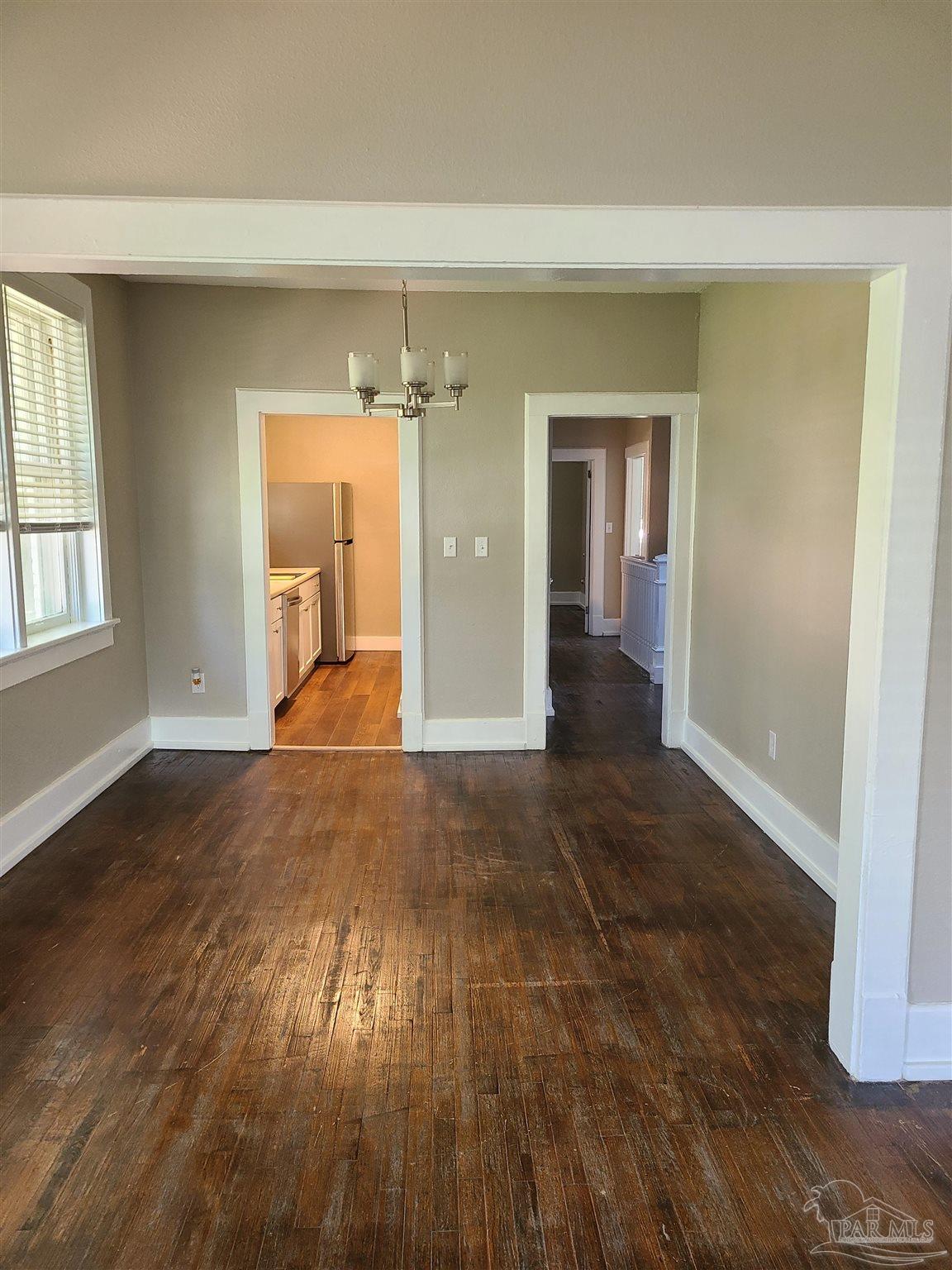 504 North Spring Street, Unit B Pensacola, FL 32501 - Photo 3 of 14 wooden floor in an empty room with a window
