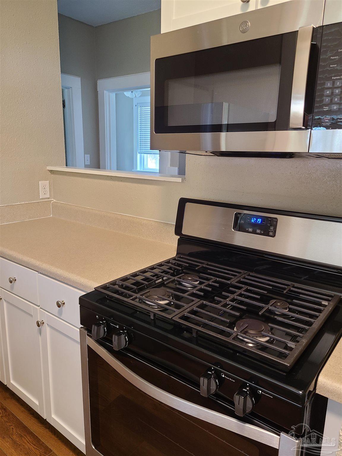 504 North Spring Street, Unit B Pensacola, FL 32501 - Photo 5 of 14 a stove top oven sitting inside of a kitchen