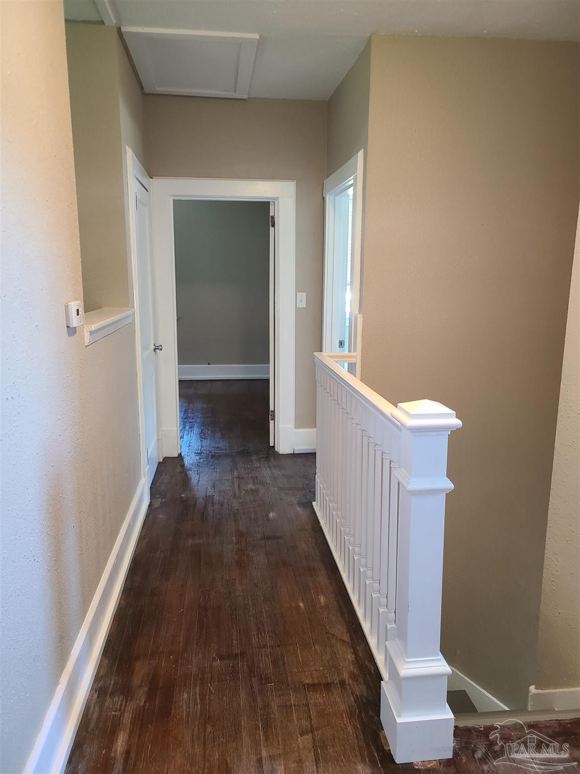 504 North Spring Street, Unit B Pensacola, FL 32501 - Photo 6 of 14 a view of a hallway with wooden floor and staircase