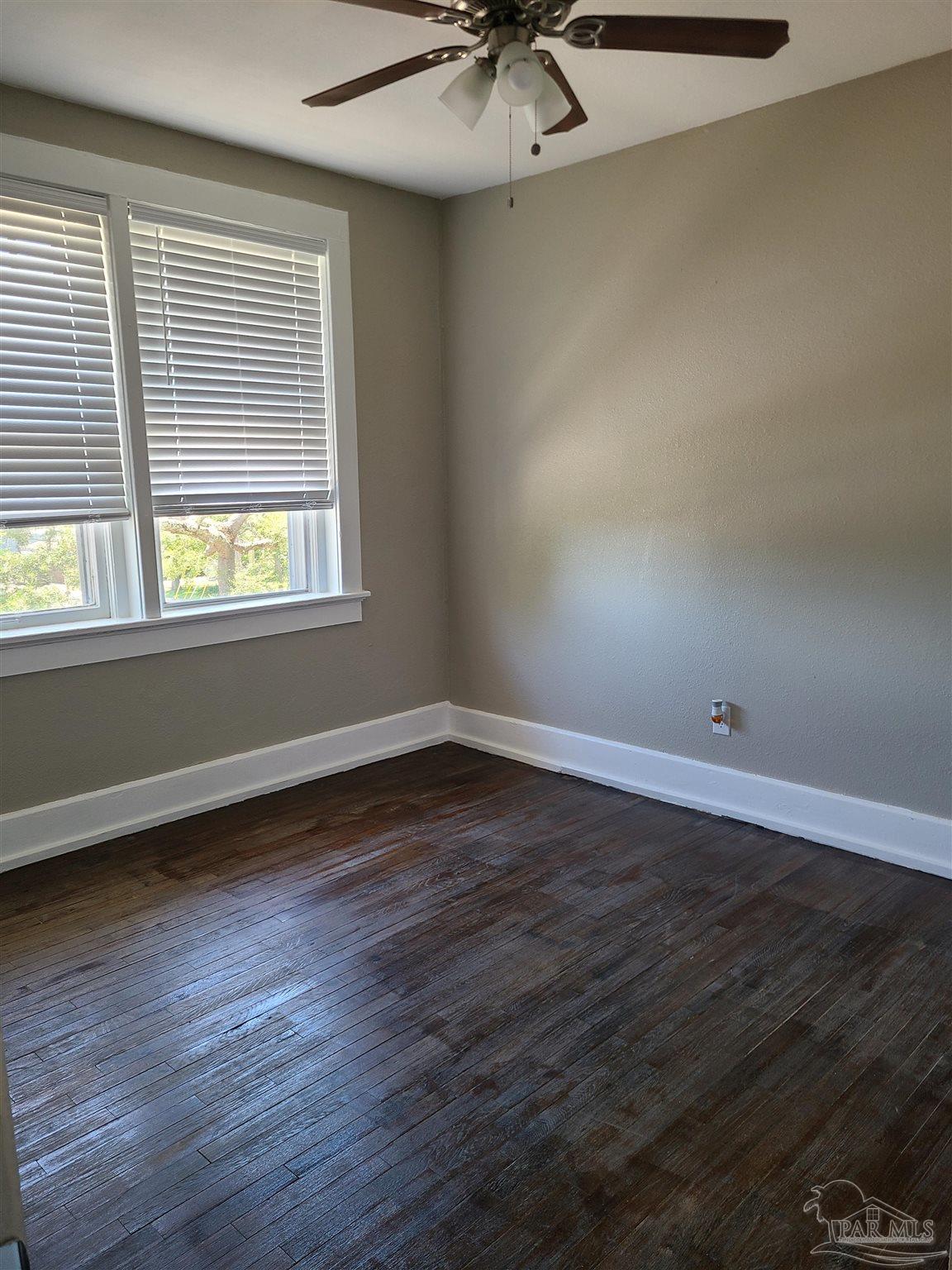 504 North Spring Street, Unit B Pensacola, FL 32501 - Photo 7 of 14 an empty room with wooden floor and windows