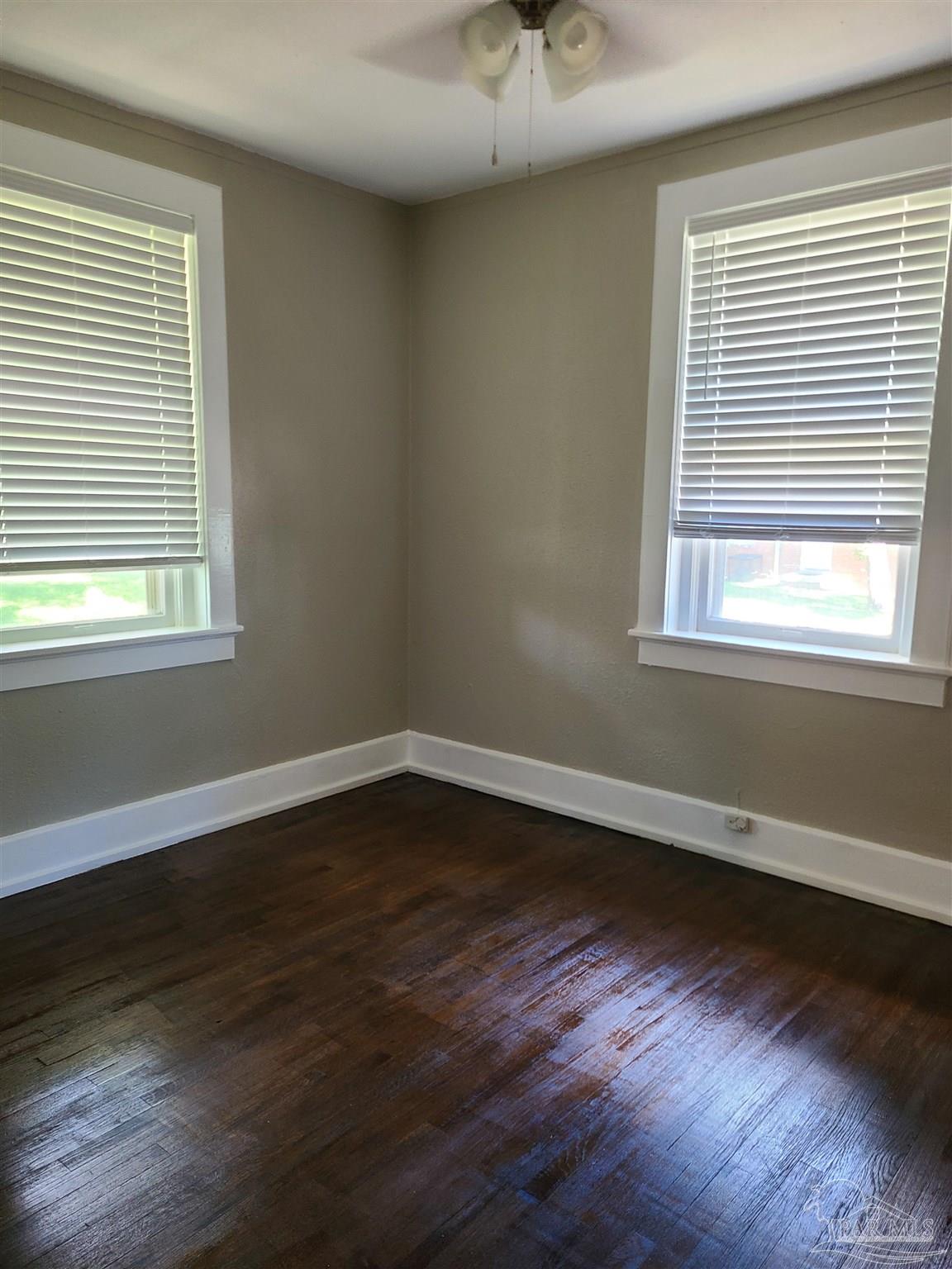 504 North Spring Street, Unit B Pensacola, FL 32501 - Photo 9 of 14 a view of an empty room with wooden floor and a window