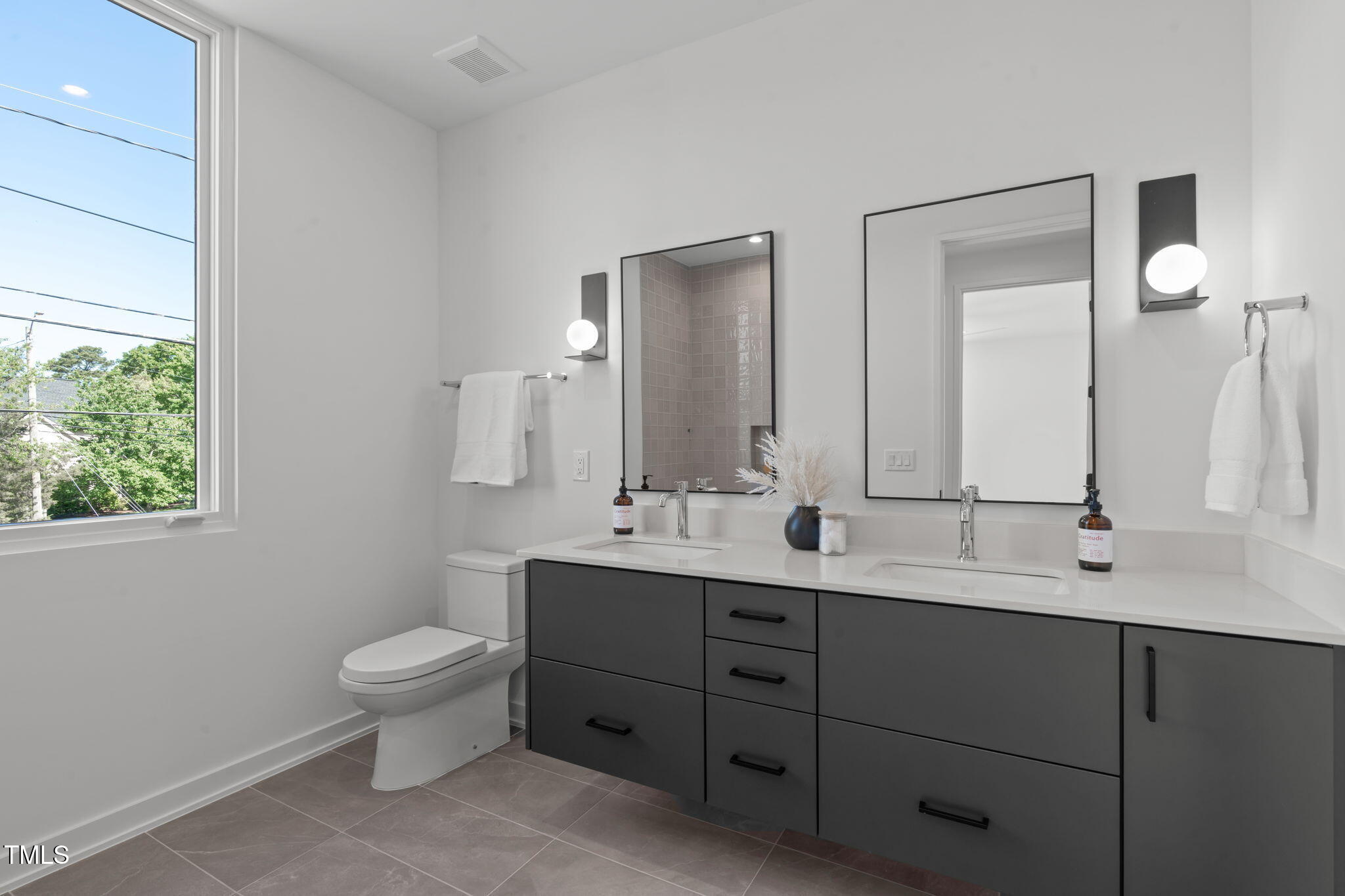 1301 Chamblee Hill Raleigh, NC 27608 - Photo 27 of 46 a bathroom with a double vanity sink a mirror and a toilet
