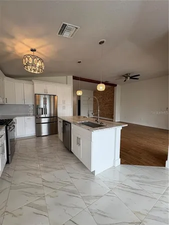 a large white kitchen with a refrigerator a stove a sink and dishwasher