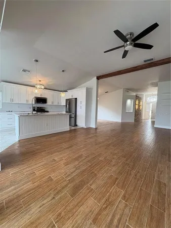 a view of a livingroom with a ceiling fan a ceiling fan and wooden floor