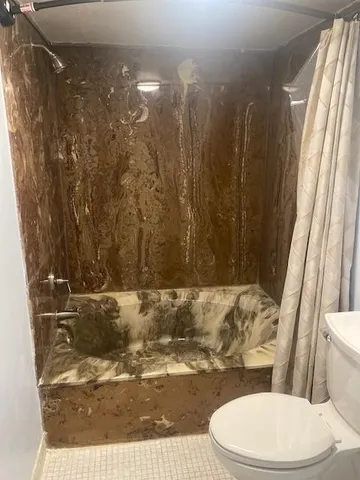 a bathroom with a toilet and a shower curtain