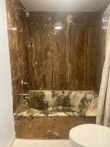 a bathroom with a toilet and a shower curtain