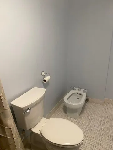 a bathroom with a toilet a sink and a mirror