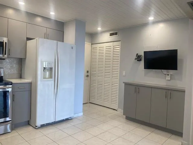 a view of a kitchen with a sink and a refrigerator