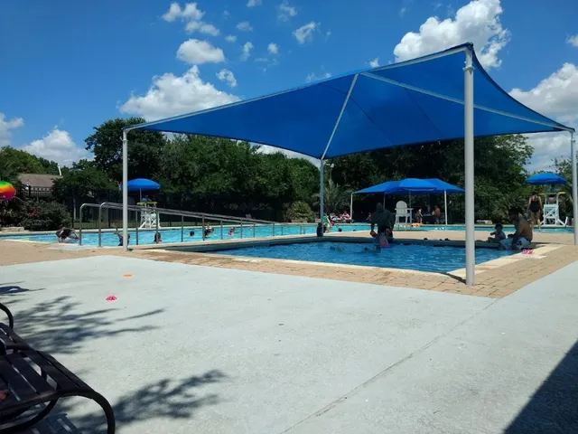 a view of a swimming pool with a table and chairs under an umbrella