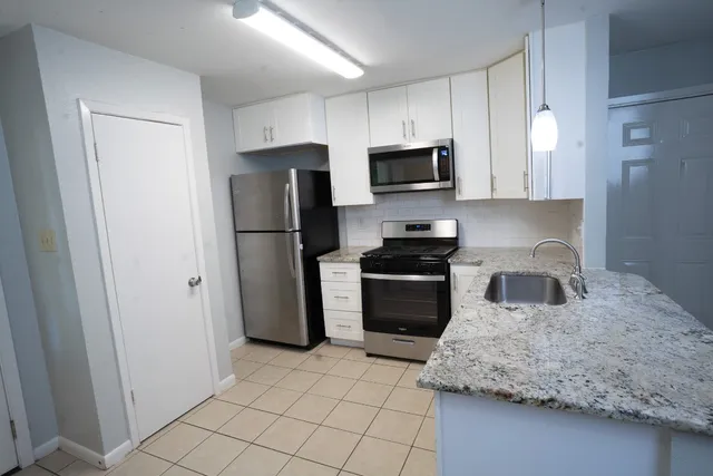 a kitchen with stainless steel appliances granite countertop a sink and a granite counter tops